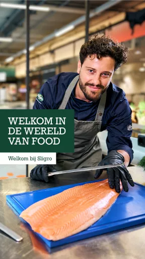Visual for Sligro, featuring a smiling professional chef preparing a fresh side of salmon on a blue cutting board, with the text 'Welkom in de wereld van food'