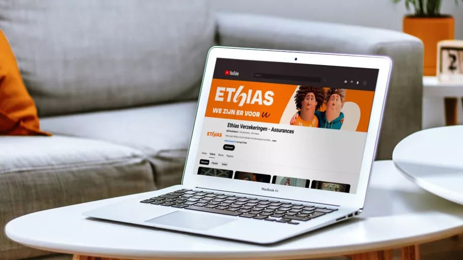 Springbok Agency digital visual mock-up for Ethias, featuring a laptop on a white coffee table displaying the Ethias YouTube channel